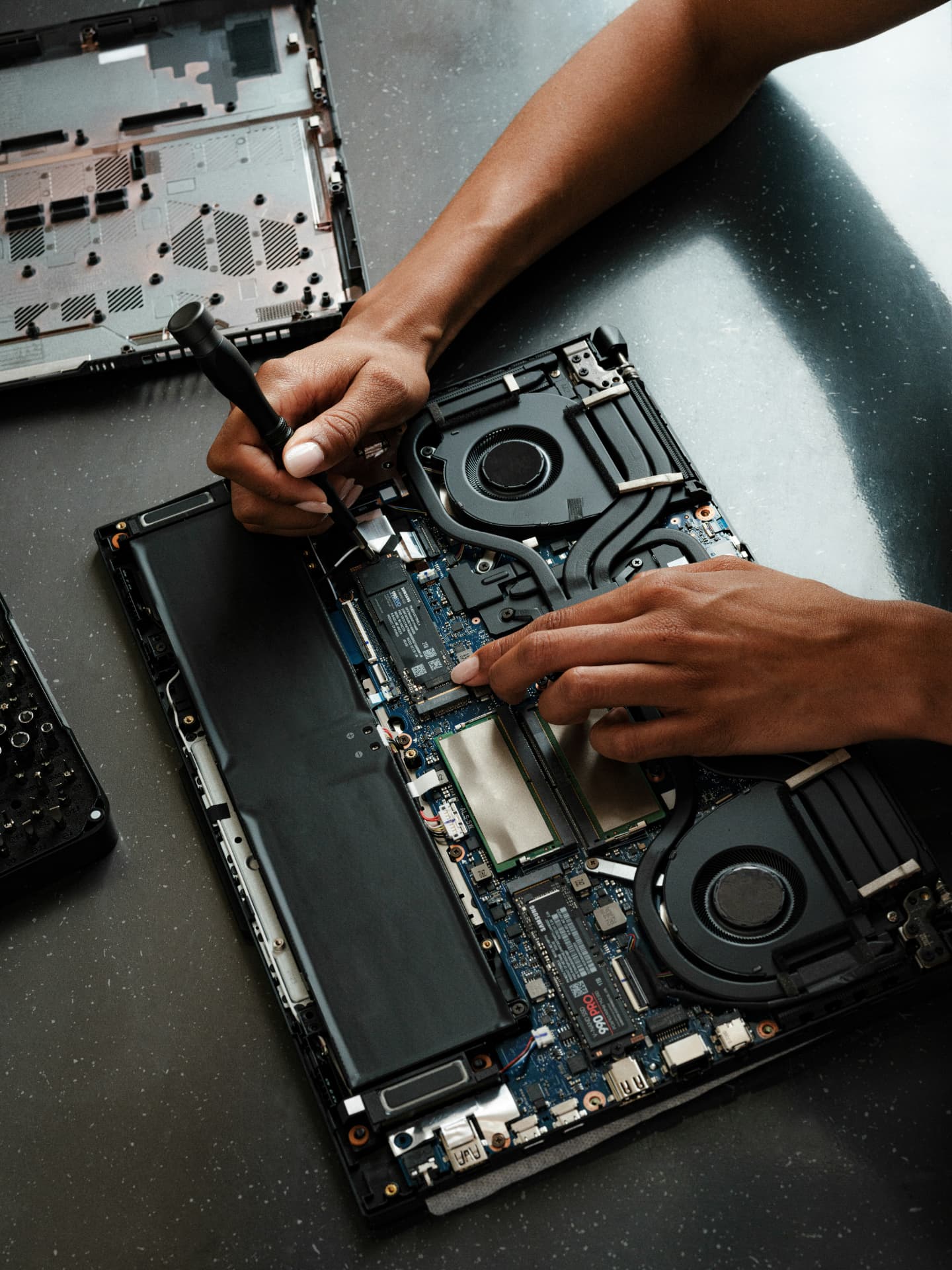 Technician diagnosing an open laptop on a professional repair bench